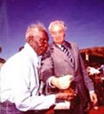 Prime Minister Gough Whitlam symbolically pours a handful of sand through Gurindji elder Vincent Lingiari's hands at the handback of the Gurindj's traditional lands in 1975