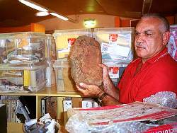 Graeme Calma holds one of the larger rocks mailed to the headquarters of the Uluru-Kata Tjuta National Park by people who took them as souvenirs and then had a change of heart