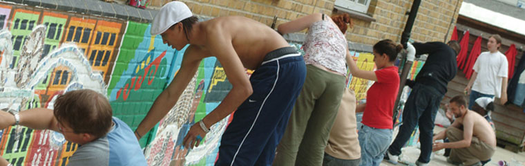 Photograph of 8 young adults painting a mural