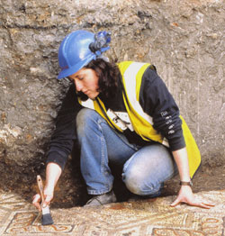 Photograph of an archaeologist on an excavation. Links to the Archaeology Service website