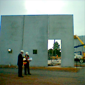 Workmen in front of partially built concrete building