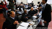 Die Angeklagten im Hamburger Prozess gegen somalische Piraten und ihre Anwälte sitzen in einem Verhandlungssaal des Landgerichts. (Foto: picture-alliance/dpa)