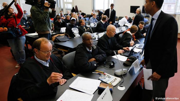 Die Angeklagten im Hamburger Prozess gegen somalische Piraten und ihre Anwälte sitzen in einem Verhandlungssaal des Landgerichts. (Foto: picture-alliance/dpa)