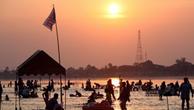 Tourists enjoy the low running Mekong River at sunset on the border of the two Southeast Asian nations