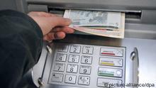 A person's hand takes money out of an ATM
Photo: Uwe Zucchi dpa +++(c) dpa - Bildfunk+++ 