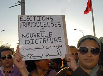 Tunisians hold up banners during a protest against the moderate Islamic party Ennahda in Tunis 