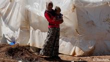 Syrische Frau in einem Flüchtlingscamp hält ihr Baby im Arm (Foto: Reuters)