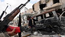 Libysche Rebellen betrachten ein zerstörtes Auto in Misrata (Foto: dpa)