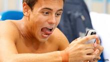 Der britische Schwimmer Tom Daley reagiert erstaunt auf eine SMS (Foto: Reuters)