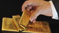 Eine Hand greift nach einem Goldbarren mit 500 Gramm, darunter liegen Goldbarren mit einem Gewicht von 1000 Gramm und zwölf Kilo, aufgenommen bei einem Goldhändler am Donnerstag (14.11.2008) in München (Oberbayern) Foto: Peter Kneffel dpa/lby +++(c) dpa - Report+++
