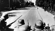 German soldiers, poised with rifle guns, look down a shaded city street in the Soviet city of Kiev, third largest in the country, Sept. 21, 1941, during Nazi occupation in World War II. (ddp images/AP Photo)

