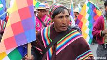 Indigenous Bolivian marches with colorful flag