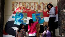 Art students from the University of Helwan decorate a wall