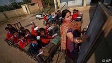 Indian school children attend a class in the open at a government school in the outskirts of Jammu, India