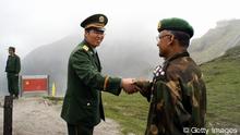 NATHU LA PASS, INDIA: A Chinese army officer (L) exchanges greetings with his Indian counterpart following a meeting among the officers, as they stand on the border of Nathu La, some 52 kilometres (33 miles) east of Gangtok, 05 July 2006. Formal trading is due to begin at the 15,000-foot (4,545 metre) Nathu La Pass on the border between India's Sikkim state and China's Tibet region. Indian businessmen and local people expect a change in the region's economy patterns following the formal resumption of trade between India and China when the Nathu La Pass, along the historic Silk Route, re-opens. AFP PHOTO/ STR (Photo credit should read STRDEL/AFP/Getty Images) 