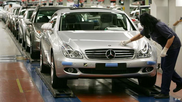 A DaimlerChrysler employee is polishing the hood of a new Mercedes Benz CLS car 