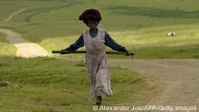 A woman is seen on her way home after a workday in the fields (Photo: AFP/Alexander JOE)