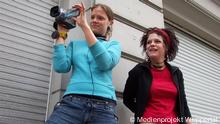 Foto 5 (Mädchen filmen) zeigt zwei Wuppertaler Schülerinnen, die sich an einer Videoproduktion des Medienprojekts Wuppertal beteiligen.Das Foto wurde der Deutschen Welle für einen Onlineartikel über 20 Jahre Medienprojekt kostenfrei zur Verfügung gestellt. Copyright: Medienprojekt Wuppertal. 
