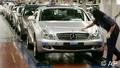 A DaimlerChrysler employee is polishing the hood of a new Mercedes Benz CLS car 