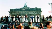 Menschen tanzen auf der Berliner Mauer