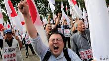 Japanese protesters shout slogans during a rally