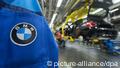 BMW auf einer Jacke, im Hintergrund sieht man eine halbfertiges Auto in der Fabrik (Foto: dpa/lby/ef/au) 