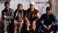 A Kirghiz family seated outside their house