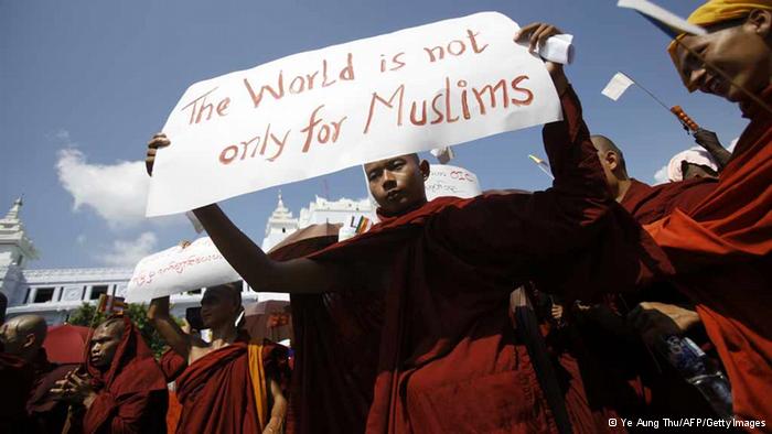 A Myanmar Buddhist monk holds a sign as he takes part in a demonstration against the Organisation of the Islamic Conference in Yangon on October 15, 2012. Thousands of monks took to the streets in Myanmar's two main cities on October 15 to protest against a world Islamic body's attempts to help Muslim Rohingya in unrest-hit Rakhine state, organisers said. AFP PHOTO/Ye Aung THU (Photo credit should read Ye Aung Thu/AFP/GettyImages)
