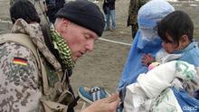 German soldier helps Afghan mother and child as part of ISAF contingent in Kabul, Afghanistan.
Photo: AP Photo/ HO