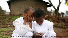 Zwei afrikanische Kinder sehen sich ein Handy an (Foto: Getty Images)