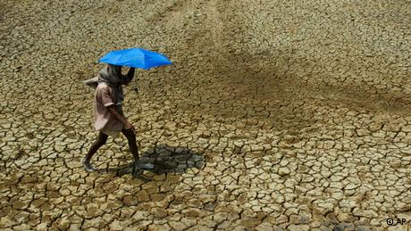 A man walks on dry soil 
(photo: AP)