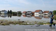 A helper walks next to houses which are flooded by the Danube river in Fischerdorf near Deggendorf, southern Germany, on June 11, 2013. AFP PHOTO / CHRISTOF STACHE (Photo credit should read CHRISTOF STACHE/AFP/Getty Images) 