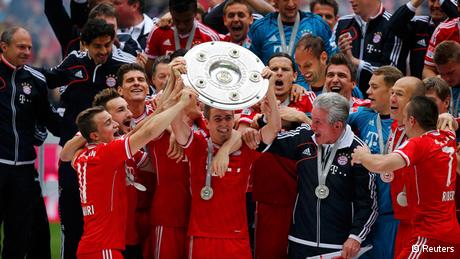 Bayern Munich's Philipp Lahm lifts up the trophy as his team celebrates after their German first division Bundesliga soccer match against Augsburg in Munich, May 11, 2013. Bayern held their 23rd German league title on Saturday after a comfortable 3-0 over Augsburg as they prepare for the all-German Champions League final against Borussia Dortmund in two weeks REUTERS/Kai Pfaffenbach (GERMANY - Tags: SPORT SOCCER) DFL RULES TO LIMIT THE ONLINE USAGE DURING MATCH TIME TO 15 PICTURES PER GAME. IMAGE SEQUENCES TO SIMULATE VIDEO IS NOT ALLOWED AT ANY TIME. FOR FURTHER QUERIES PLEASE CONTACT DFL DIRECTLY AT + 49 69 650050.